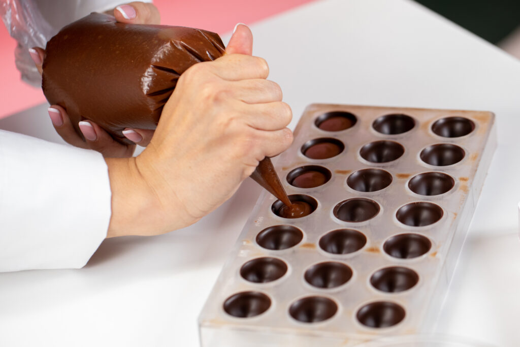 tempered chocolate is poured into molds to create bars